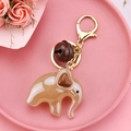 Close-up of cute beige acrylic elephant keychain with heart ear and small brown bell - Light Coffee
