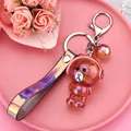 Brown iridescent bear keychain with red headphones and colorful PVC hand strap - Glowing Bear [brown]