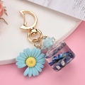 Détail du porte-clés fleur bleue avec fermoir lune et pendentif bouteille liquide - Boucle Lune+Bouteille+Fleur / Bleu Royal