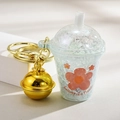 Luminous milk tea cup keychain with orange flower pattern and shiny gold bell - Bell Style [Blue]