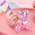 Nahaufnahme der facettierten rosa Acrylbär-Schlüsselanhänger mit Goldverschluss - Lila