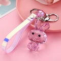 Detailaufnahme eines lila facettierten Acryl-Hasen-Schlüsselanhängers mit Hologramm-Band - Lederband + Hase + Perle / Lila