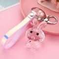 Nahaufnahme von rosa facettiertem Acryl-Hasen Schlüsselanhänger mit holografischem Armband - Lederband + Hase + Perle / Rosa