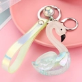 Close-up of a swan acrylic keychain with iridescent sequins and laser PVC strap - Grass Green