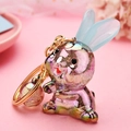 Gros plan d'un porte-clés lapin irisé coloré avec anneau doré sur un fond rose pastel - Gris Clair