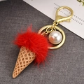 Close-up of red plush ice cream keychain with white pearl and gold metal hook - Pink