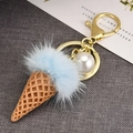 Détail du porte-clés cornet de glace en fourrure bleue avec perle et clip doré - Rose bonbon