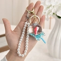 Pink fish aquarium liquid keychain with white faux pearl strap and golden ring - Lollipop Shape - Pearl Chain & Buckle Style