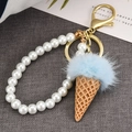 Cute ice cream keychain with blue faux fur ball, white pearls, and gold metal hardware - Light Blue