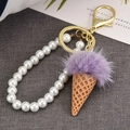 Detail of ice cream keychain with purple faux fur pompom and white pearl strap - Purple