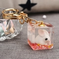 Gros plan du lapin 3D en résine avec paillettes roses sur porte-clés en alliage doré - Rose