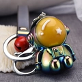 Macro shot of an iridescent astronaut keychain with a red ball and silver ring - Gray