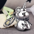 Close-up of silver unicorn keychain with translucent green strap and tiny bell detail - White Zirconia (Silver)