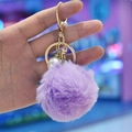 Detail of purple faux fur ball keychain with gold clasp and sparkling rhinestone accent - Purple