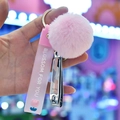 Detailopname van een roze pompon sleutelhanger met siliconen koord en nagelknipper - Roze