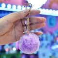 Detail of purple faux fur keychain with golden heart clasp and mini drink cup charm - Purple
