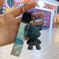 Dettaglio del portachiavi a forma di orso stellato verde con cinturino in corda e gancio - Verde
