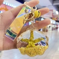 Handheld shell keychain with golden starfish, yellow bell and iridescent strap details - Yellow