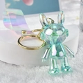 Close-up of iridescent acrylic rabbit keychain with golden ring and transparent strap - Green