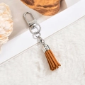 Brown faux suede tassel keychain with silver metal spring clasp on white fur texture - D-Clasp Mini Tassel / Ginger Yellow