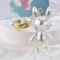 Detail of colorful acrylic space rabbit keychain with iridescent laser effect and gold ring - White