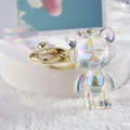 Close-up of a colorful acrylic bear keychain with iridescent coating and golden metal ring - White