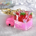 Detail of strawberry themed liquid keychain with pink heart sequins and golden bell - Cube