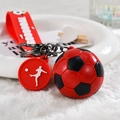 Dettaglio del portachiavi calcio rosso con cinturino GOOOOAL e charm sagoma giocatore - Stile Cordino / Rosso
