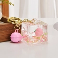 Cute peach-themed liquid quicksand cube keychain with pink bell and golden metal ring - Peach Style Square