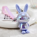 Macro shot of colorful iridescent purple bunny keychain with a pink silicone hand strap - Purple