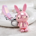 Detail of a shiny holographic pink rabbit keychain with silver metal clip and PVC wrist strap - Pink