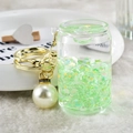 Detailed shot of a green liquid quicksand keychain with gold hardware and large pearl charm - Green
