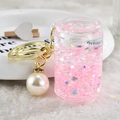 Dettagli di sabbia liquida rosa e paillettes a stella nel portachiavi a forma di lattina - Rosa