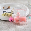 Detailed macro view of pink liquid quicksand bear keychain with gold metal clasp - Candy