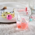 Macro shot of liquid quicksand acrylic keychain with cute pink bear and golden bell - Milk Tea Cup