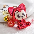 Rode metalen beer sleutelhanger met gouden belletje en iriserende bal op pluche achtergrond - Rode Cartoon Beer / Rood