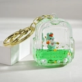 Close-up of green mini backpack keychain with liquid glitter sand and a small bunny - Green