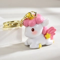 Dettaglio di un portachiavi a forma di unicorno bianco con ali rosa e chiusura dorata - Rosa