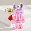 Detail of a pink pearlescent gradient rabbit keychain with China text and golden ring - Purple Pink