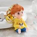 Cartoon boy keychain wearing yellow panda hoodie and blue pants on decorative tray - Yellow Boy