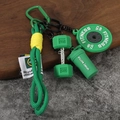 Détail macro du porte-clés fitness avec disque de musculation vert et haltère - Style Haltère / Emballage en vrac / Vert