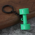 Detail of a bright green dumbbell-shaped keychain with 50KG text on dark wood surface - Gym Dumbbell-Green