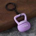 Detail shot of a mini purple kettlebell keychain with white Yoga lettering and black metal ring - Yoga Kettlebell-Purple