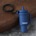 Close-up of a blue mini cup keychain with Persist text on dark wood background - Yoga Tumbler-Blue