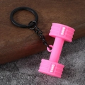 Macro shot of a pink mini dumbbell keychain with 50KG engraving and black metal ring - Gym Dumbbell-Pink