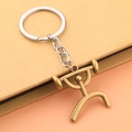 Macro shot of a bronze weightlifting figure pendant on a silver metal keychain - Weightlifting Style - Antique Bronze