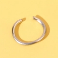 Close-up of minimalist silver metal open ring on a solid yellow background - Silver Hanging Ring