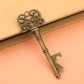 Detailed macro of vintage bronze key bottle opener with intricate scrollwork patterns - Antique Bronze