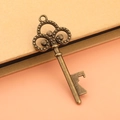 Macro view of vintage bronze key bottle opener showing intricate scroll details - Bronze