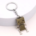Creative bronze robot keychain with movable joints on a white minimalist display stand - Antique Bronze
